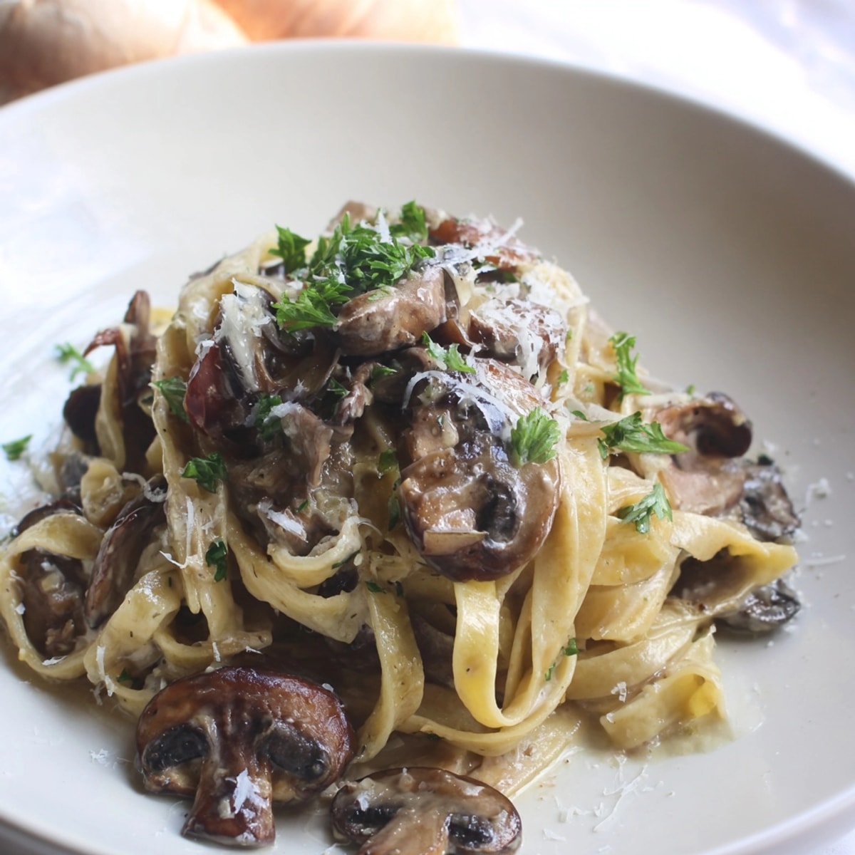 Close-up shows Creamy Truffle Mushroom Pasta with parsley and parmesan, ready to serve.