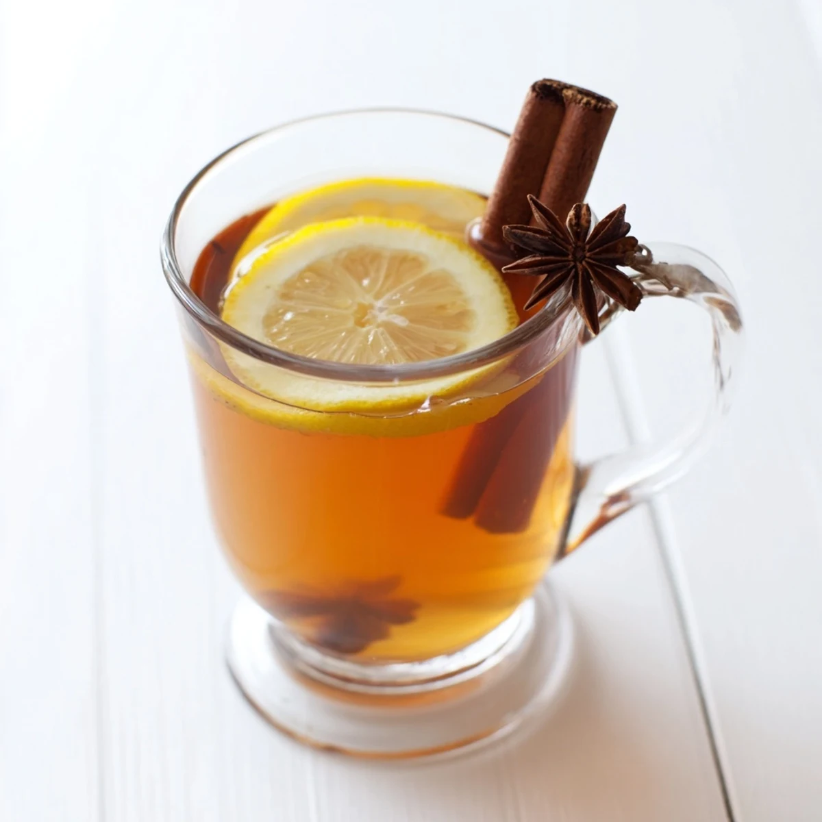 Steaming Spiced Hot Toddy in a clear mug, garnished with lemon and star anise, a perfect cozy drink.