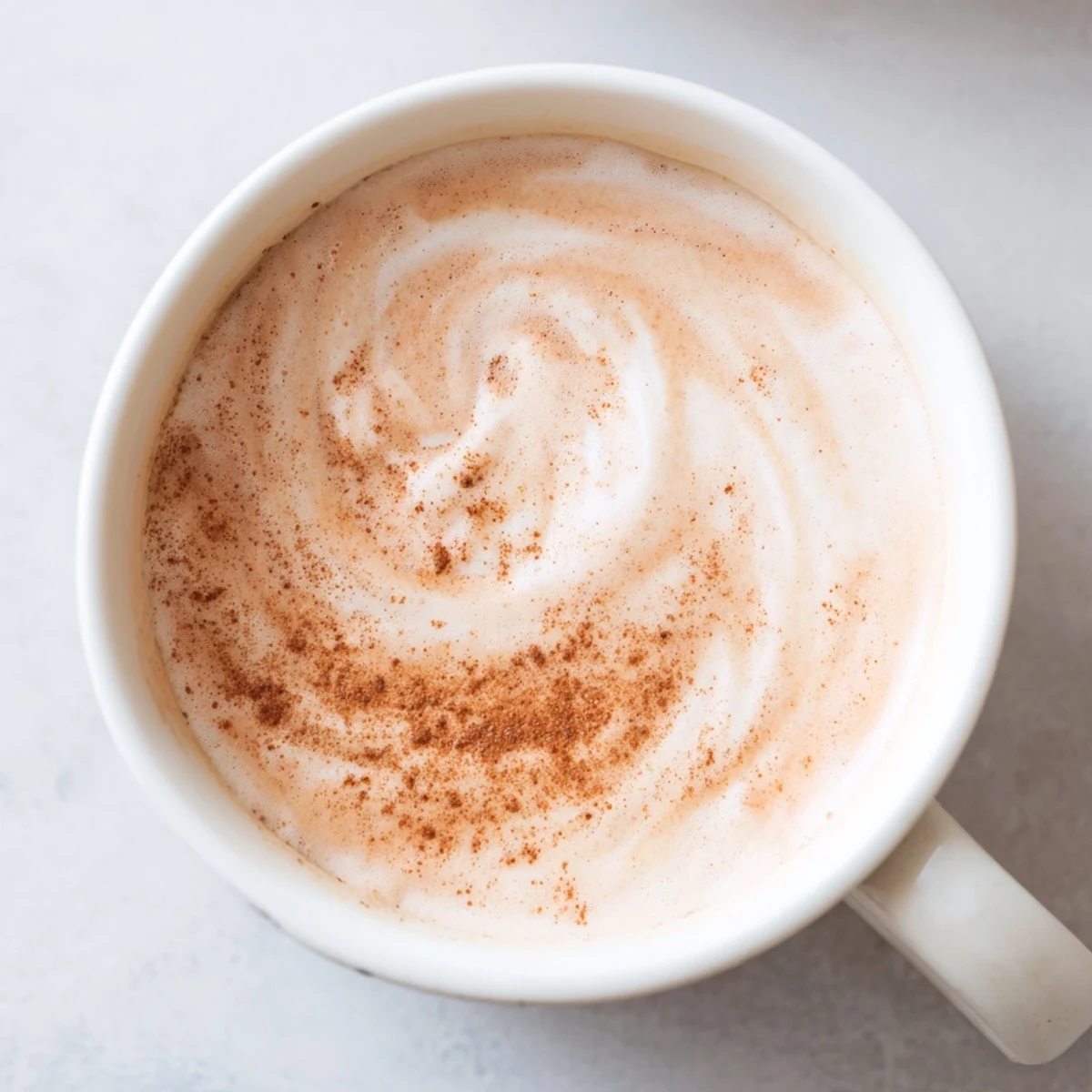 A close-up shot of rich, homemade Creamy Milk, perfectly swirled and garnished with cinnamon.