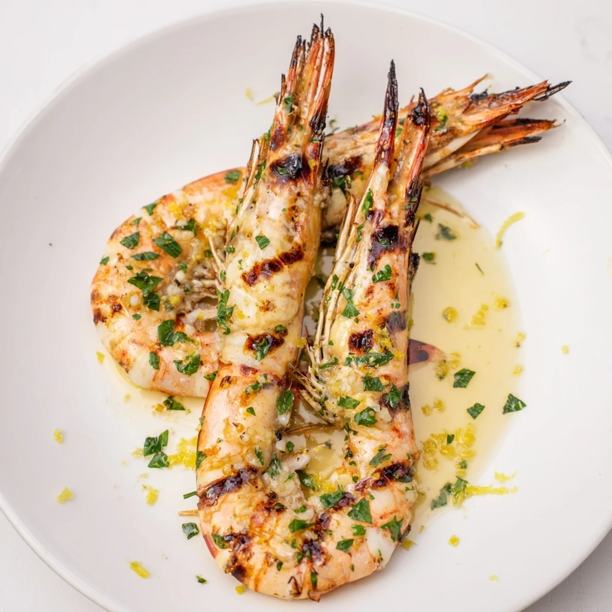 Enjoy a plate of flavorful grilled shrimp, perfectly charred and paired with a refreshing lemon garnish.