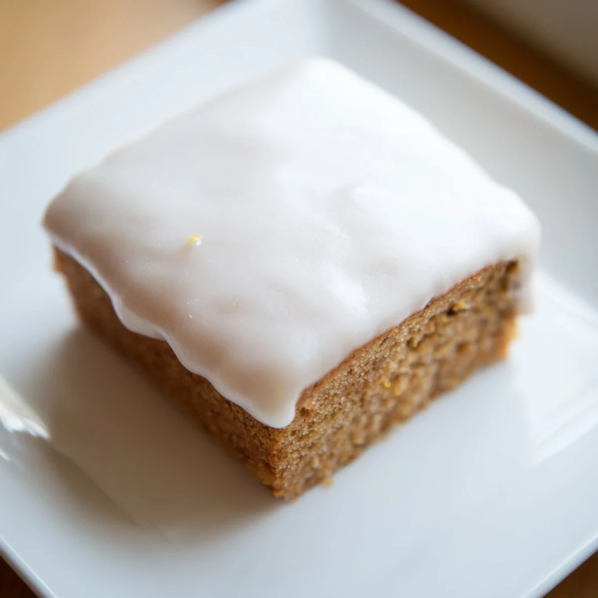 Enjoy a slice of iced gingerbread—the perfect dessert for any cozy gathering, ready to eat.