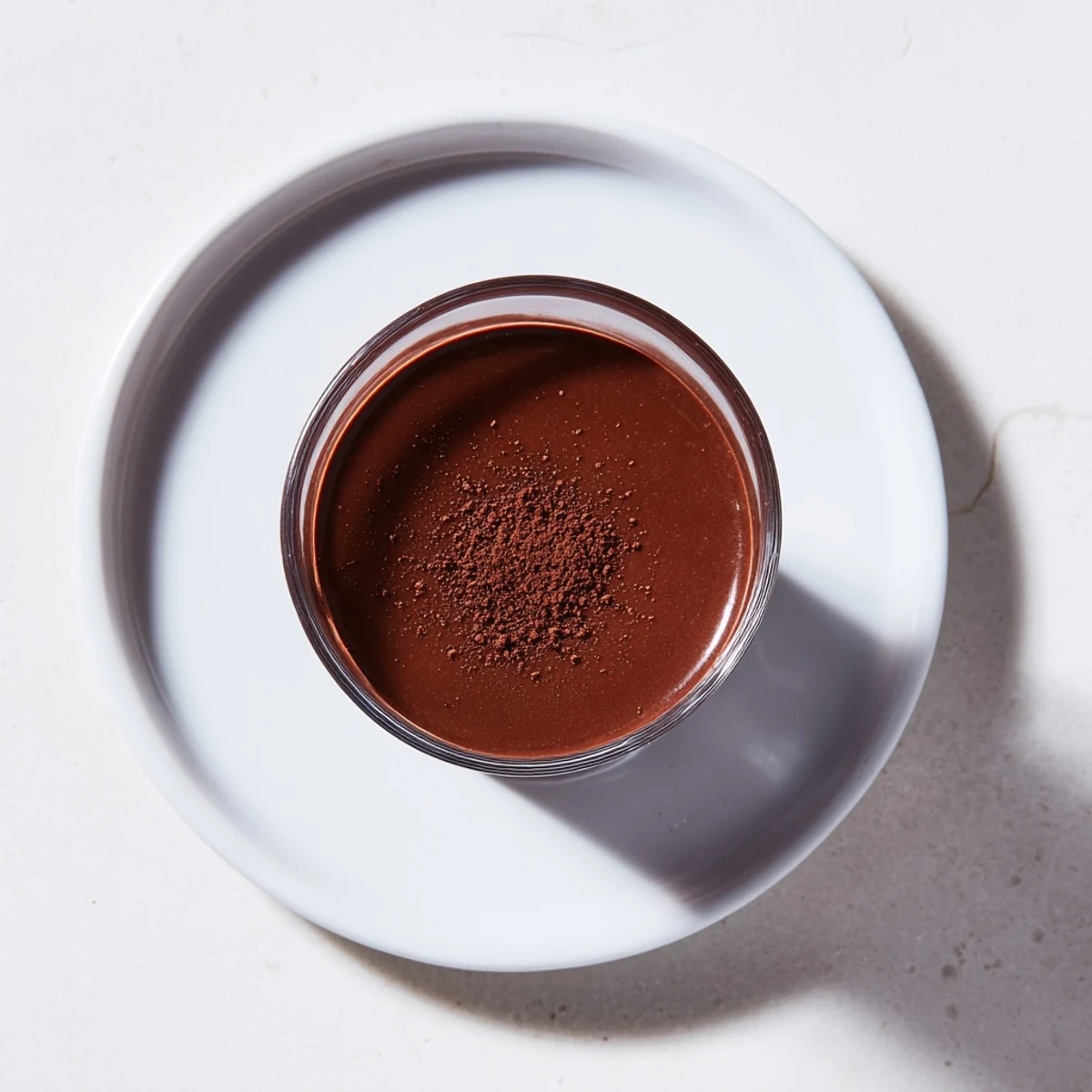 Enjoy a warm, single serving of shot chocolate, garnished with cocoa and served in tiny glasses.