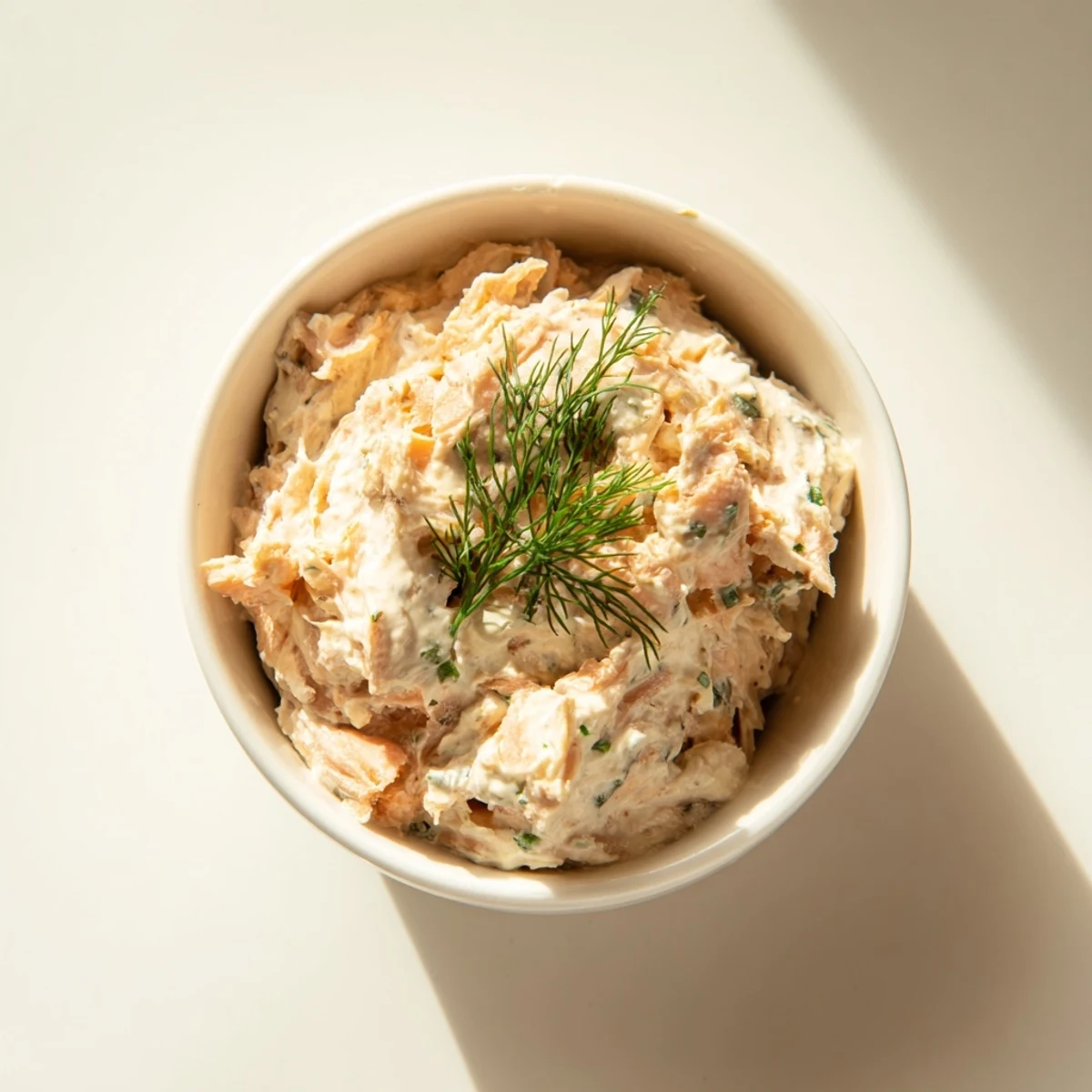 Delicious Smoked Salmon Pâté with fresh herbs, ready to be spread onto baguette slices.