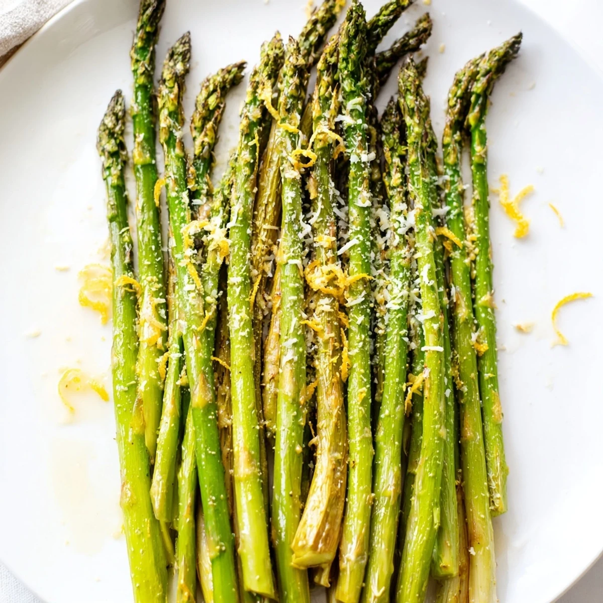 Tender, roasted asparagus with Parmesan, ready to serve, featuring a squeeze of fresh lemon juice.