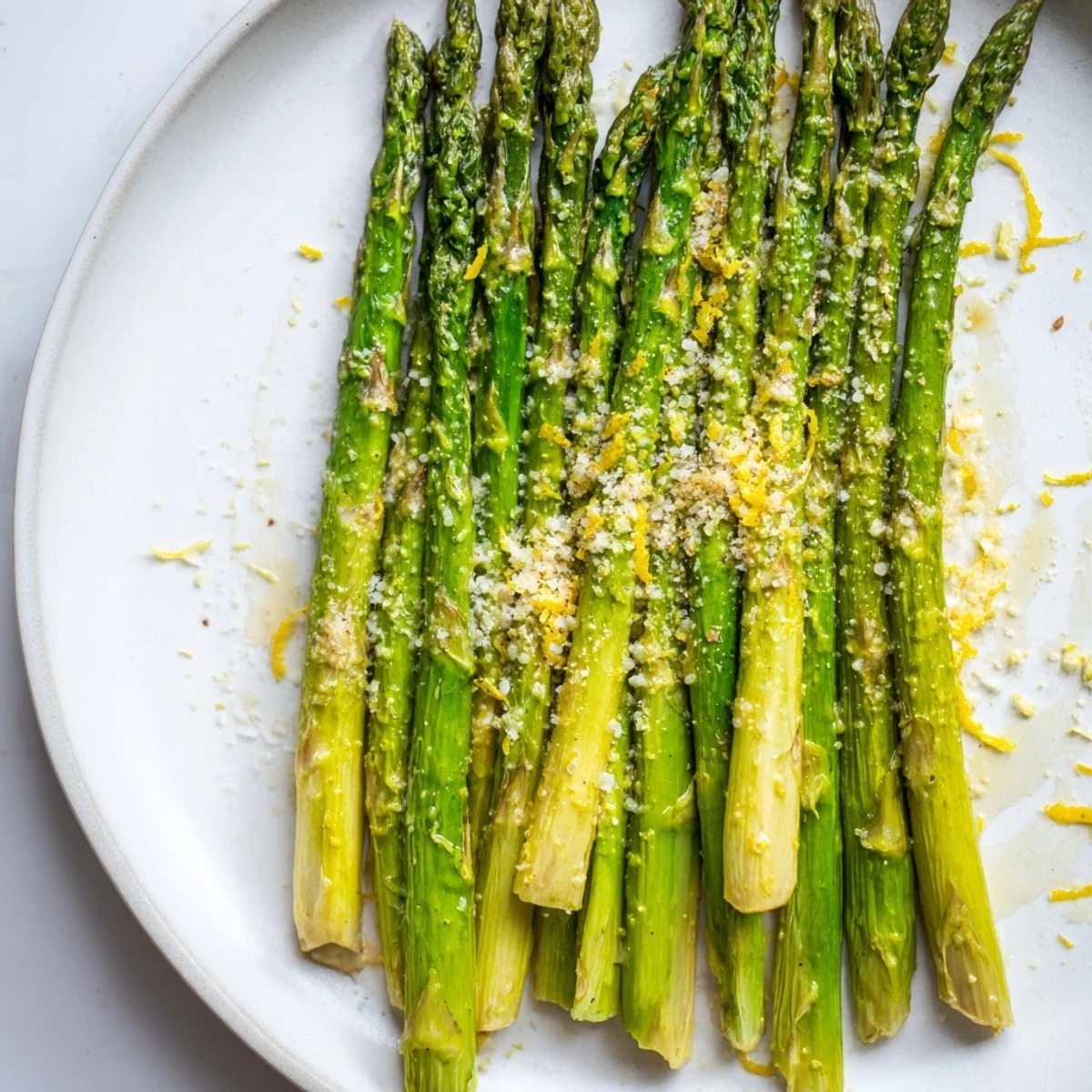 Freshly roasted asparagus recipe, showing vibrant green spears and a dusting of Parmesan cheese for flavor.