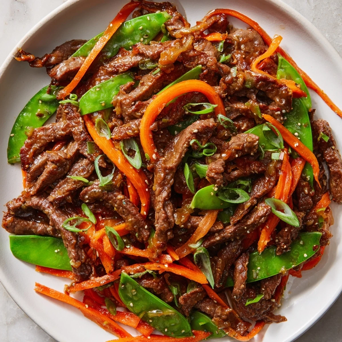 A steaming bowl of colorful beef stir fry, highlighting fresh snow peas and carrots in a wok.