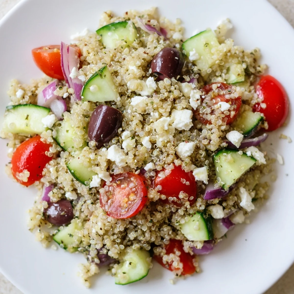 A bowl full of delicious Mediterranean Quinoa Salad with Cucumber, ready to be enjoyed as a refreshing lunch.