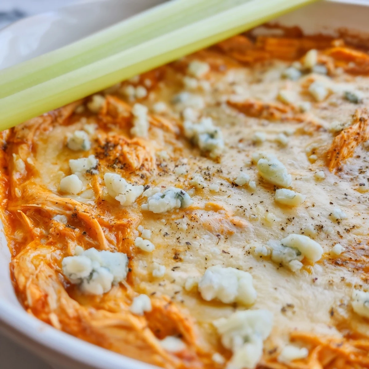 Sizzling hot Spicy Buffalo Chicken Dip with blue cheese and celery sticks, ready for game day.
