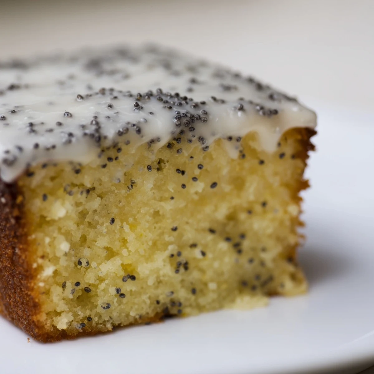 Freshly baked Lemon Drizzle Traybake with Poppy Seeds cooling on a rack, featuring a golden crust and soaked texture.