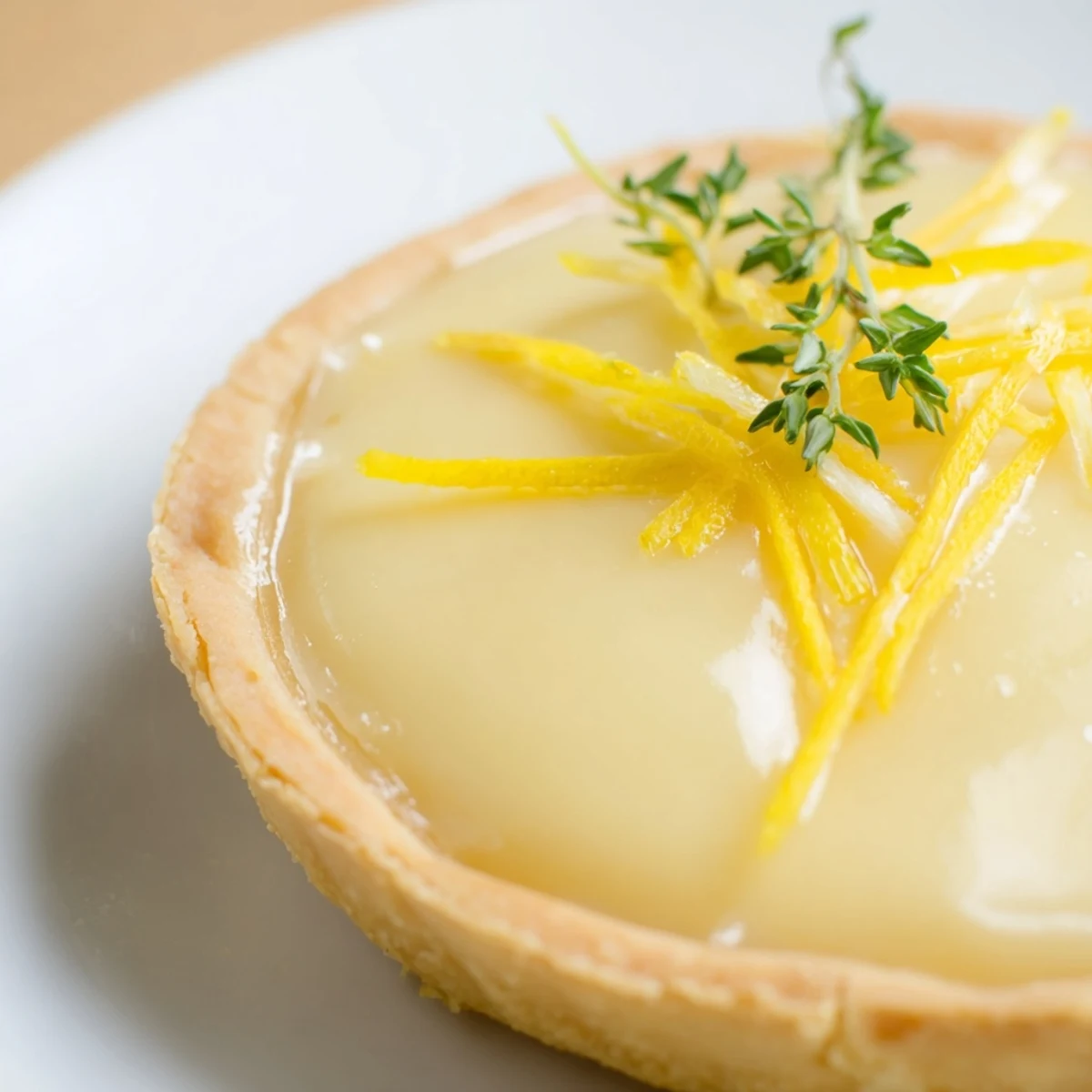 Freshly baked Lemon Appetizer Tart with golden, flaky crust and a bright, creamy lemon filling, garnished with zesty lemon strips. 