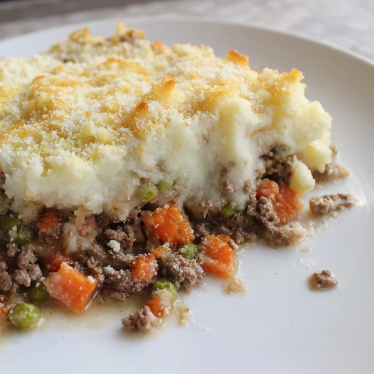Juicy, savory Beef Shepherds Pie with Cauliflower Mash bubbling beside a crisp green salad, ready for a weeknight comfort meal.