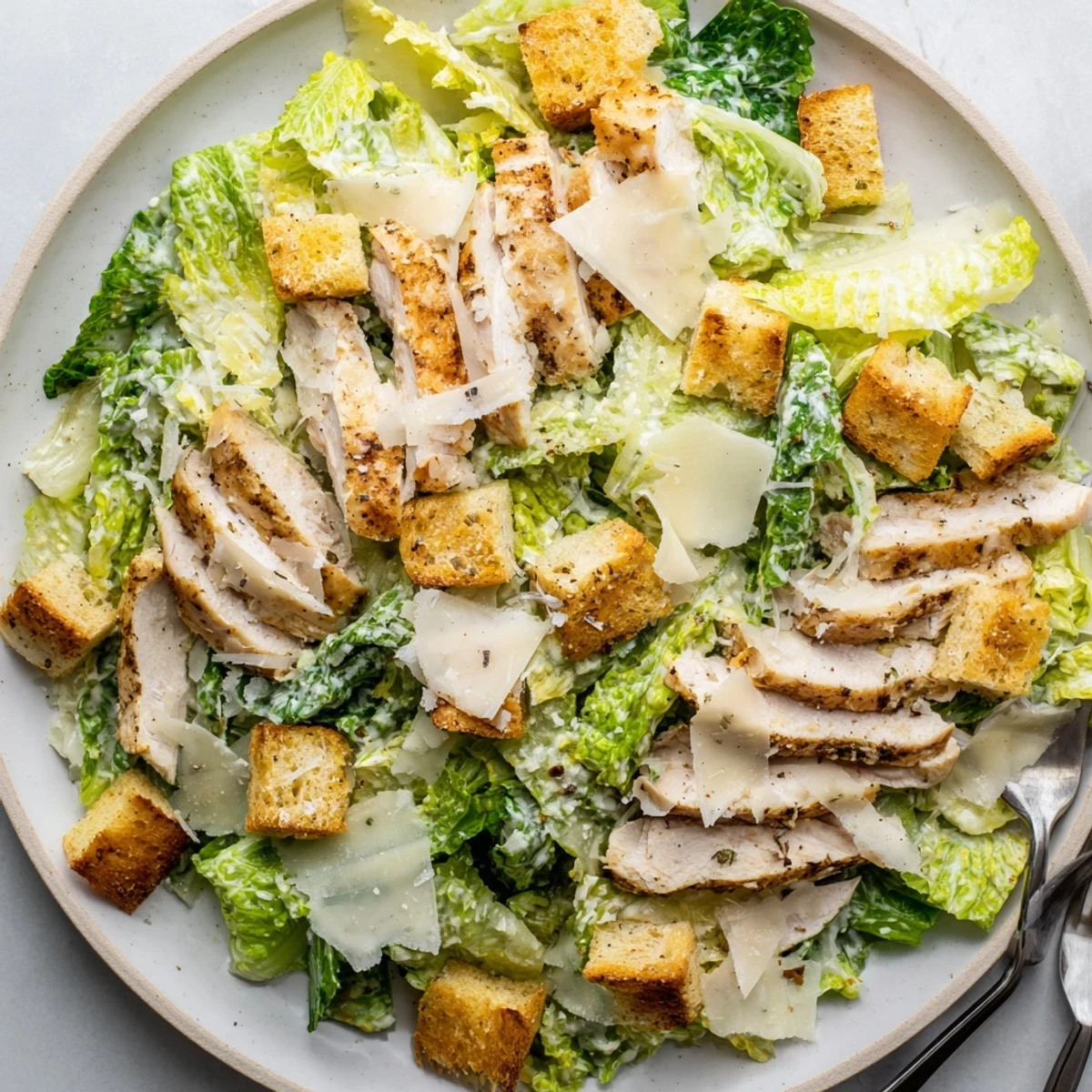 Freshly baked croutons and tender grilled chicken top this vibrant Chicken Caesar Salad for dinner.