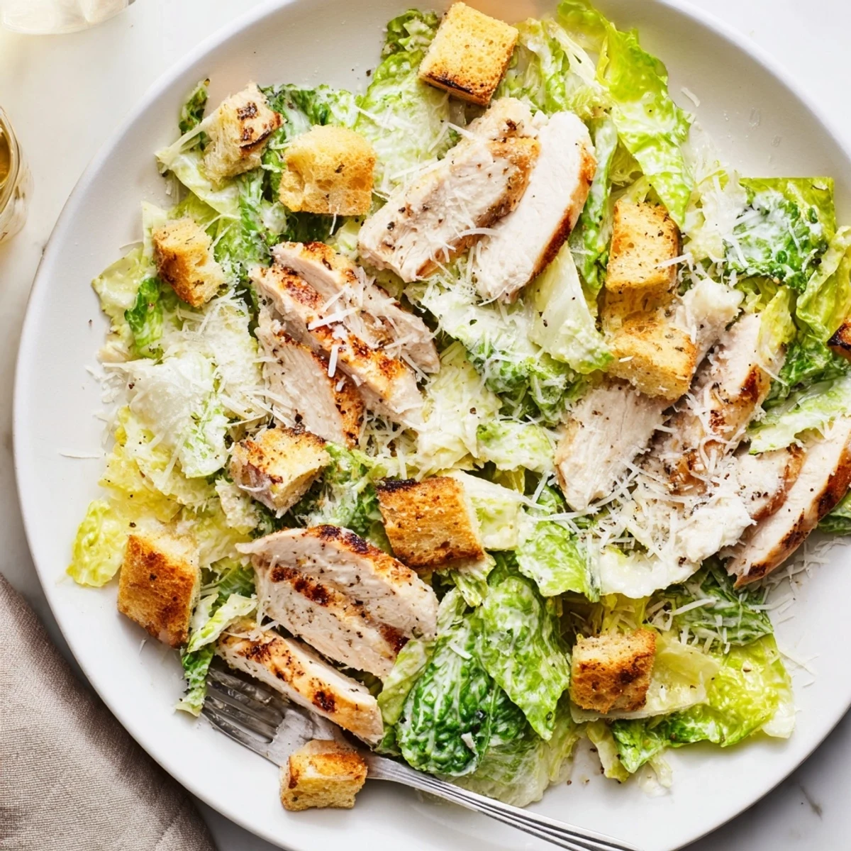 A hearty Chicken Caesar Salad with homemade croutons, freshly grated Parmesan, and savory grilled chicken.  