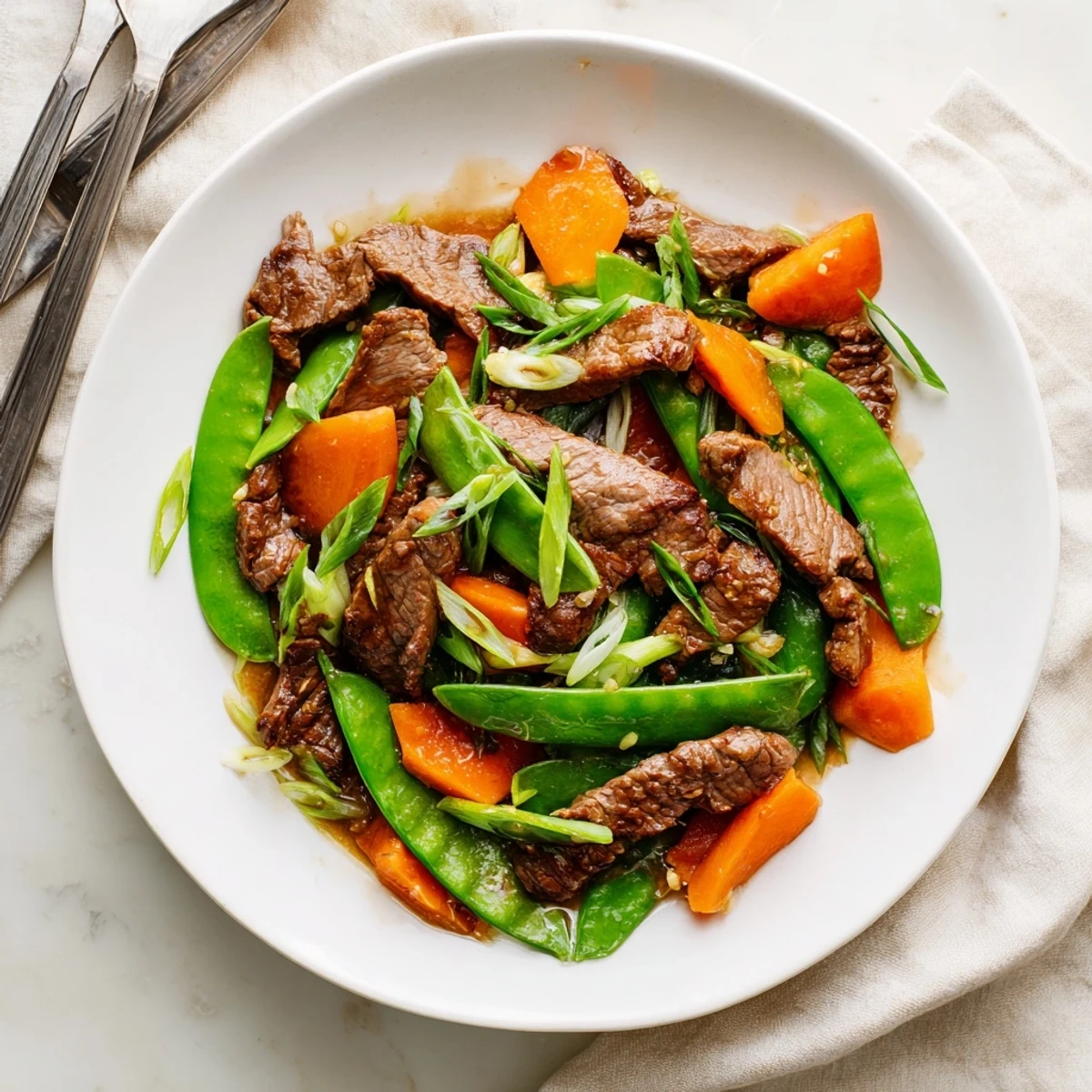 A colorful Beef Stir Fry with Snow Peas and Carrots sizzles, blending sweet carrots and crunchy peas with marinated beef slices.