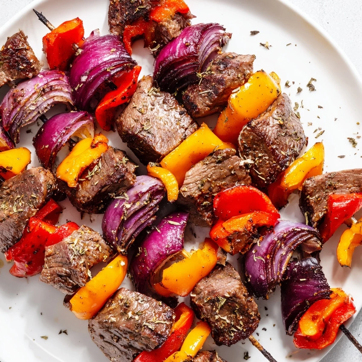 Tender marinated beef skewers paired with colorful bell peppers and onions on a rustic wooden serving board.