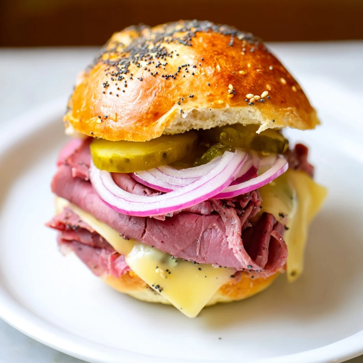 Hearty Corned Beef Sliders with Mustard stacked high with Swiss, tangy mustard, and pickles on a baking sheet for a party.