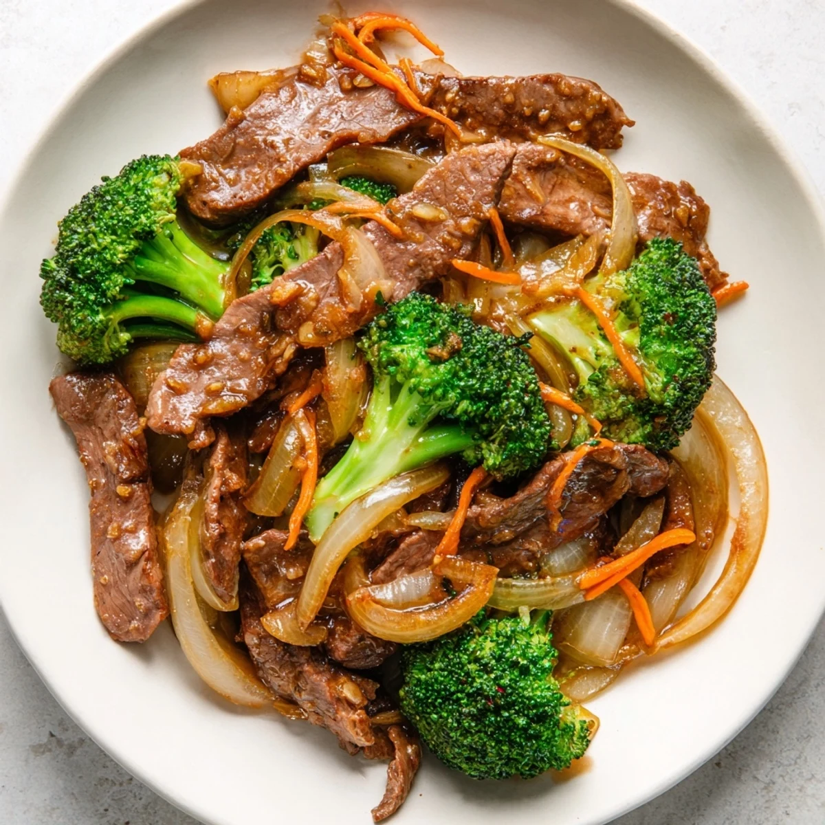 Steaming Beef and Broccoli Stir Fry with Ginger Soy Sauce served over white rice, with a chopstick resting on the side for a family meal.