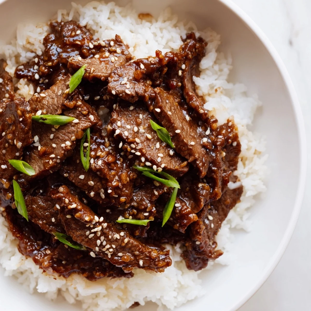 Savory and slightly sweet, this Ultimate Slow Cooker Mongolian Beef is garnished with green onions and sesame seeds for a perfect meal.