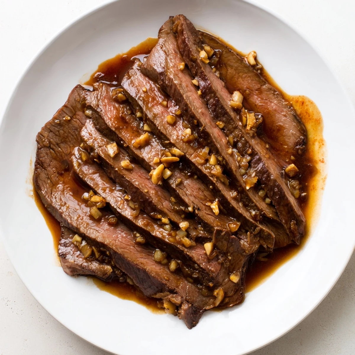 Savory slices of Ultimate Slow Cooker Mongolian Beef simmer in a glossy, sweet sauce over fluffy white rice.