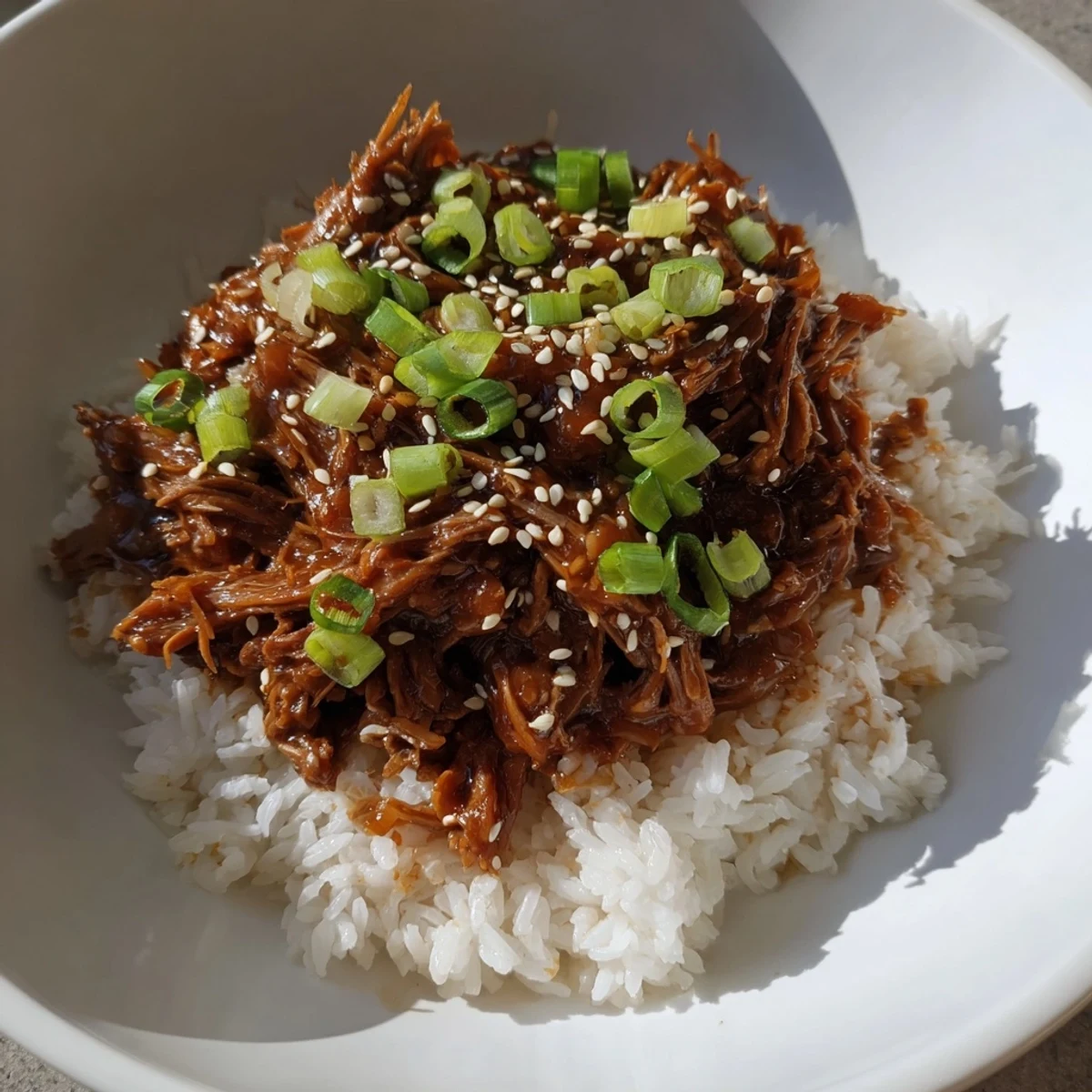 Homemade Crock Pot Korean Beef shredded in a slow cooker, showcasing juicy beef chunks in a thick red-brown sauce with pear and ginger notes.