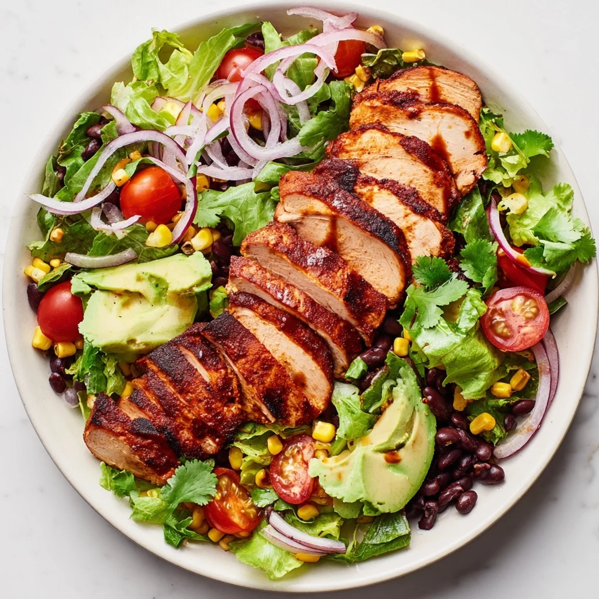 A tangy lime dressing glistens over the mixed greens topped with smoky chipotle chicken slices.
