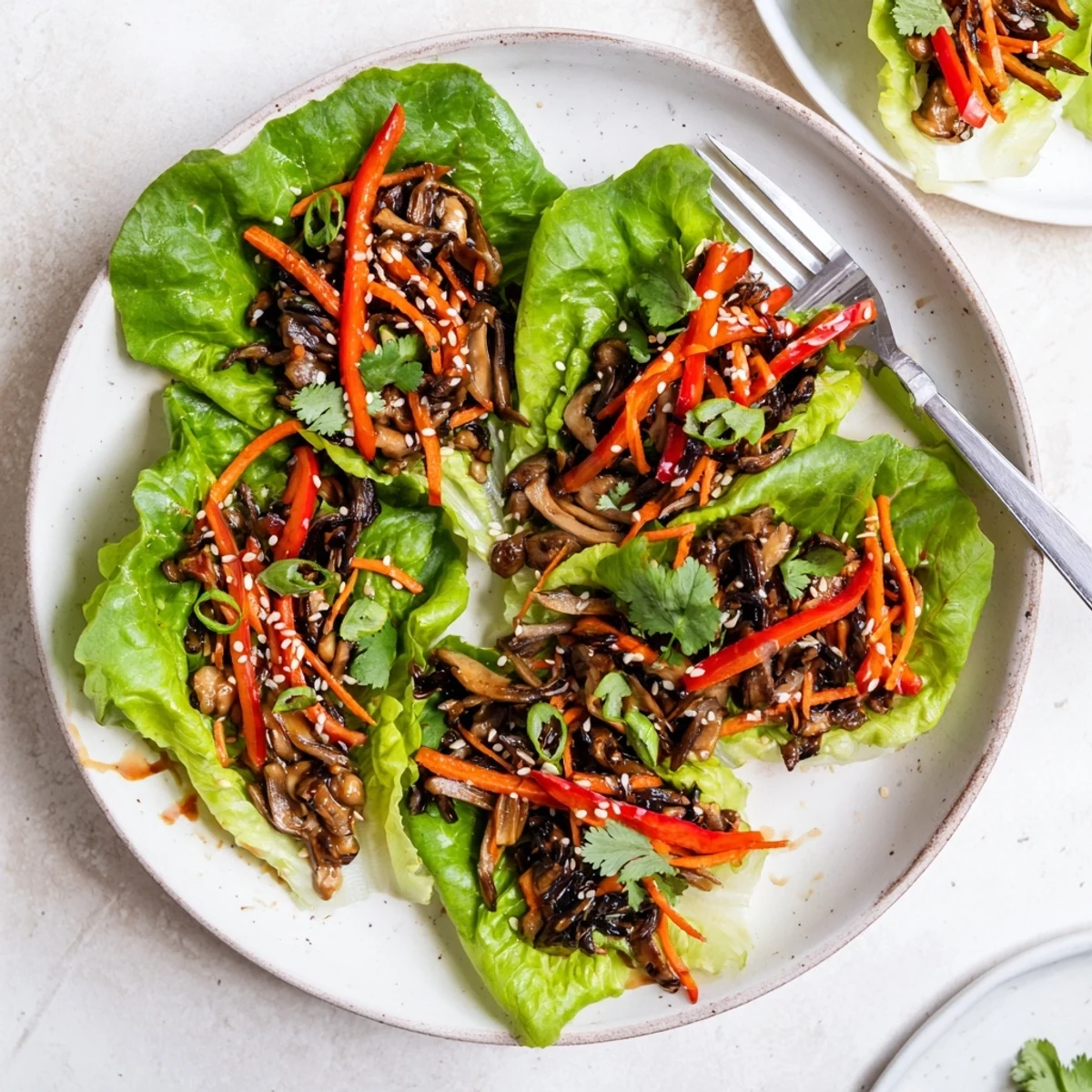 Tender Shiitake Mushroom Lettuce Wraps garnished with sesame seeds and cilantro, ready to eat appetizer.