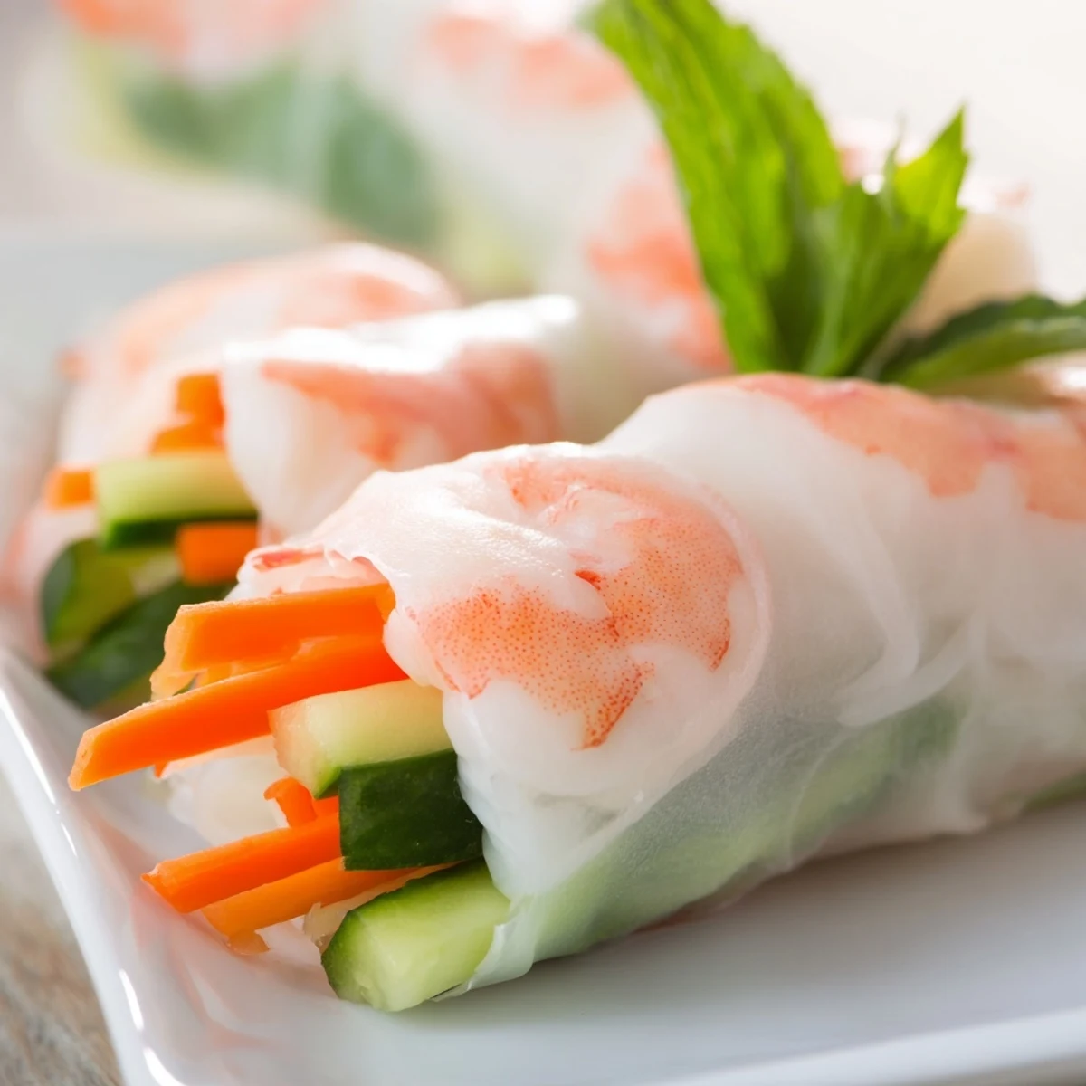 A close-up of vibrant Vietnamese Spring Rolls with shrimp, crisp veggies, and herbs wrapped in translucent rice paper, served with a rich peanut dipping sauce.