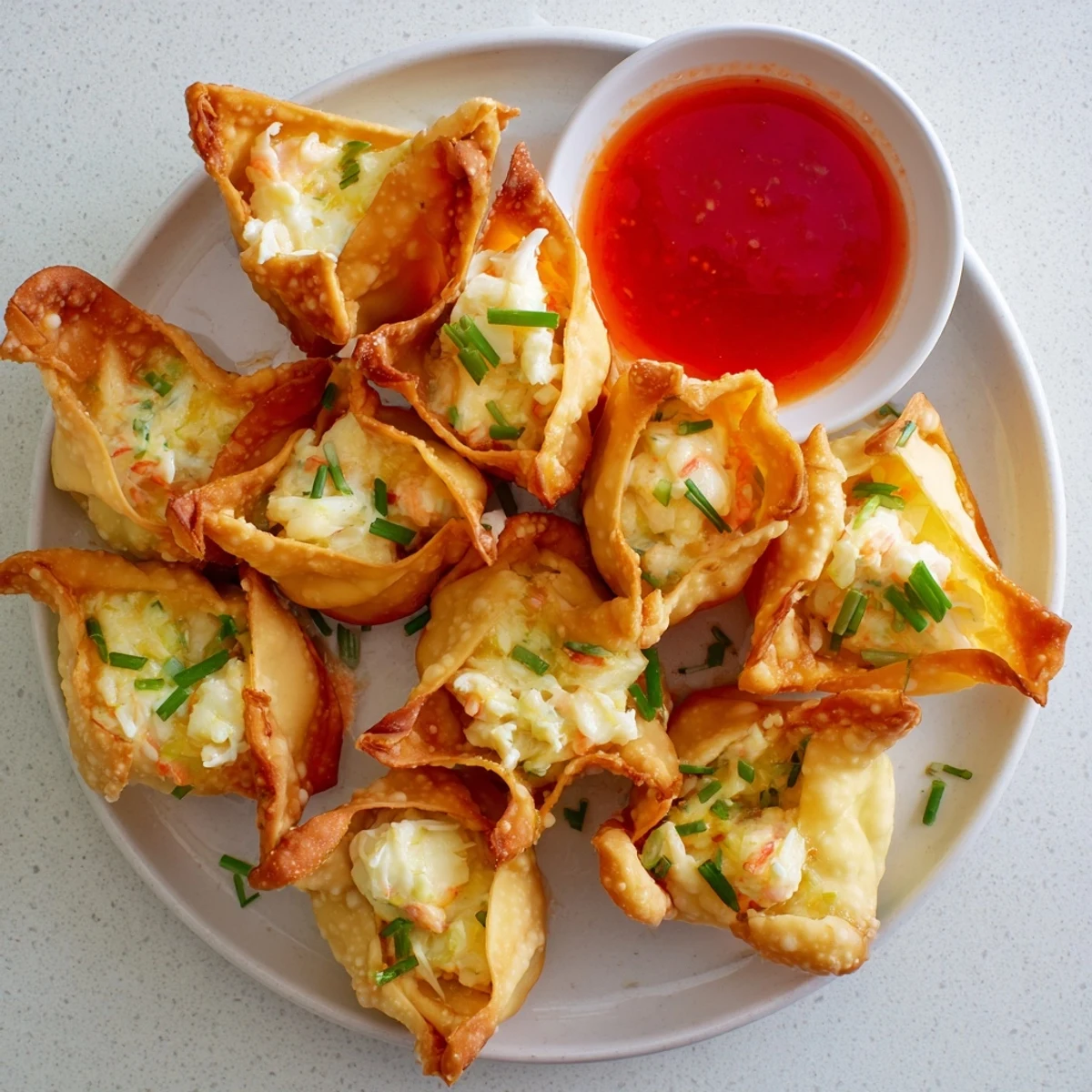 Close-up of golden Crispy Crab Rangoon Bombs with Creamy Filling on a wooden board, showing the rich texture and garnish.