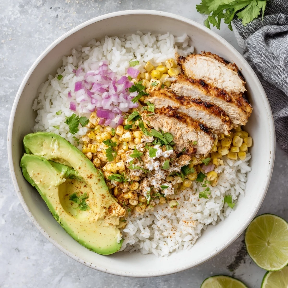 Fluffy rice topped with grilled chicken and charred Street Corn Chicken Rice Bowl, garnished with avocado and cilantro.