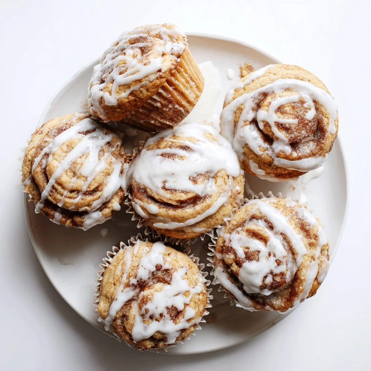 Freshly baked cinnamon roll protein muffins with spiraled cinnamon filling and powdered sugar topping
