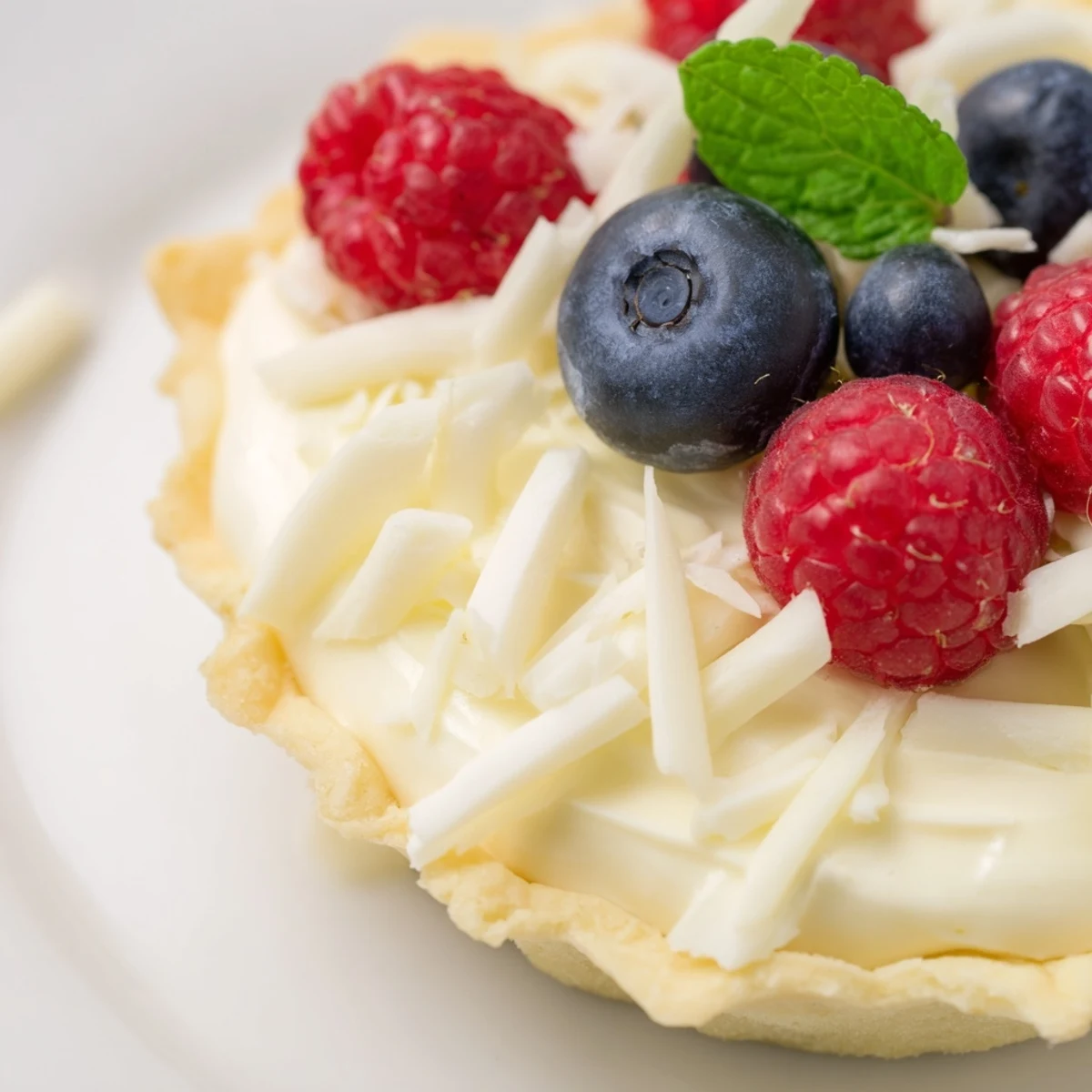 Delicate individual tarts filled with creamy white chocolate mousse and garnished with mint