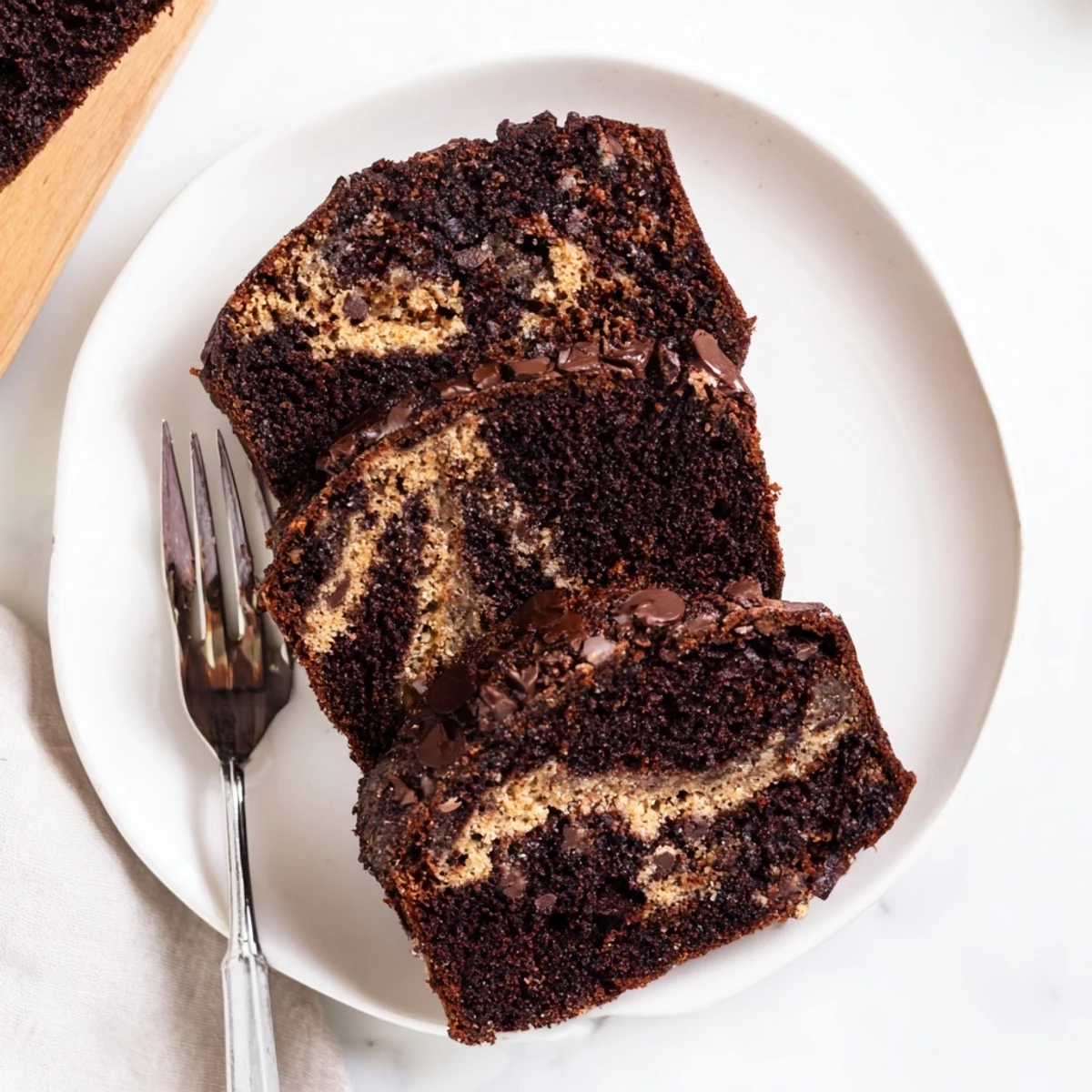Freshly baked chocolate peanut butter banana bread cooling on a wire rack with golden edges and peanut butter swirls
