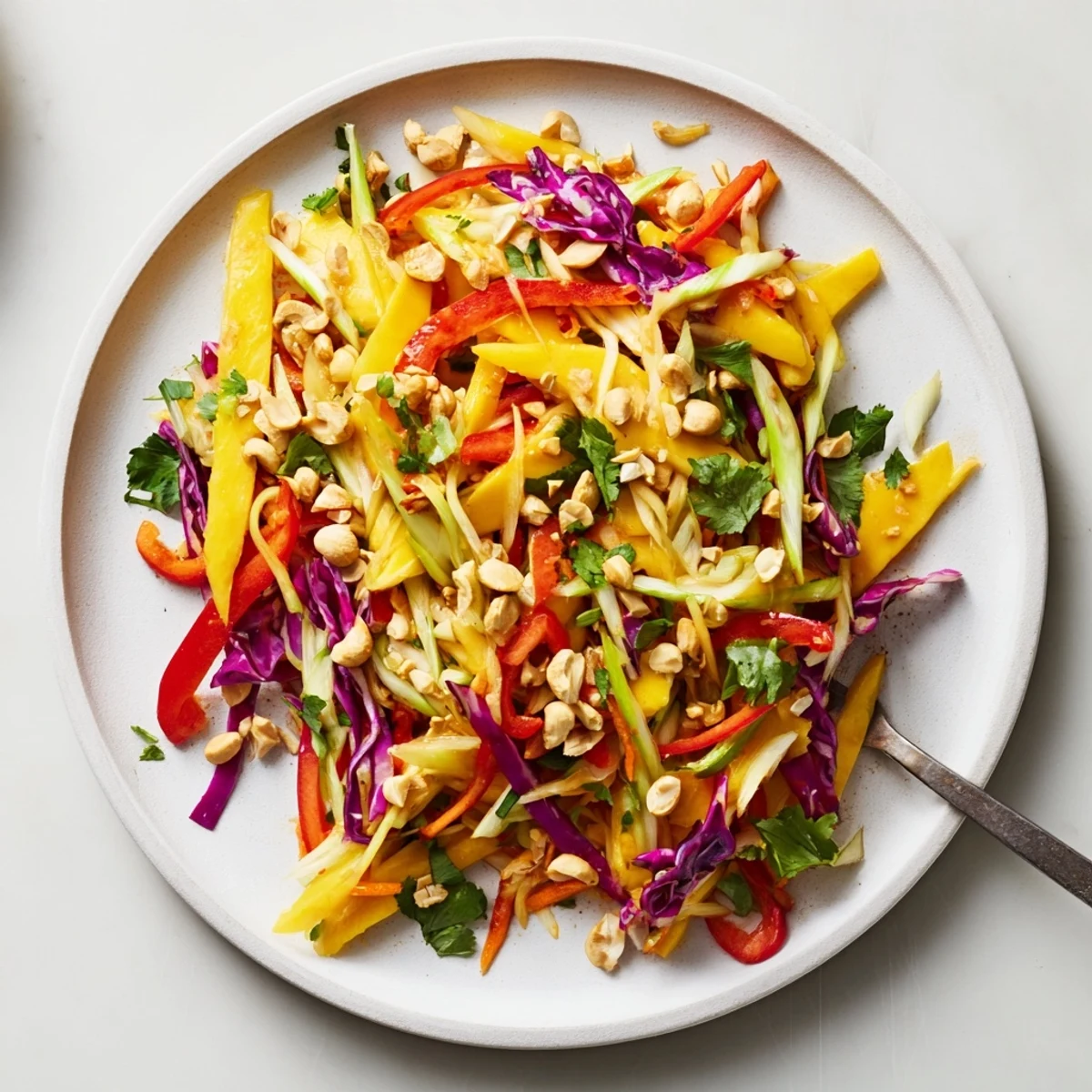 Colorful mango slaw with red cabbage, carrots, and fresh cilantro in a bright bowl