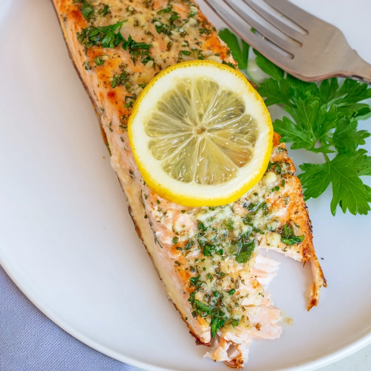 Tender oven baked salmon with lemon slices on a white serving platter