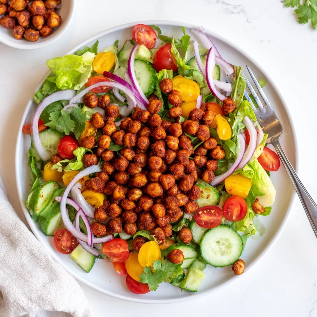 Colorful crispy chili lime chickpea salad bowl topped with spiced roasted chickpeas and cherry tomatoes