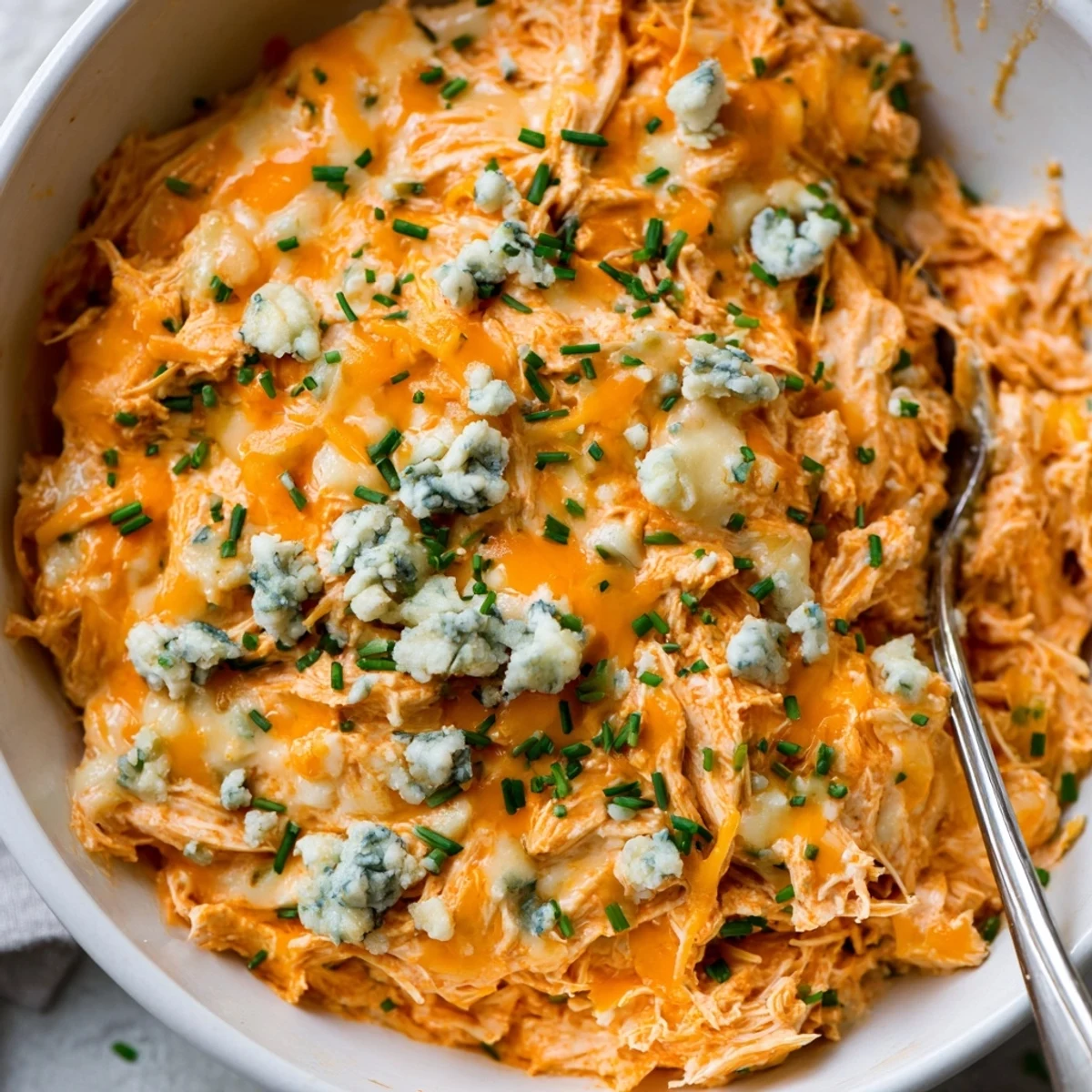 Steaming Crockpot Buffalo Chicken Dip topped with fresh chives and served with crunchy celery sticks for game day