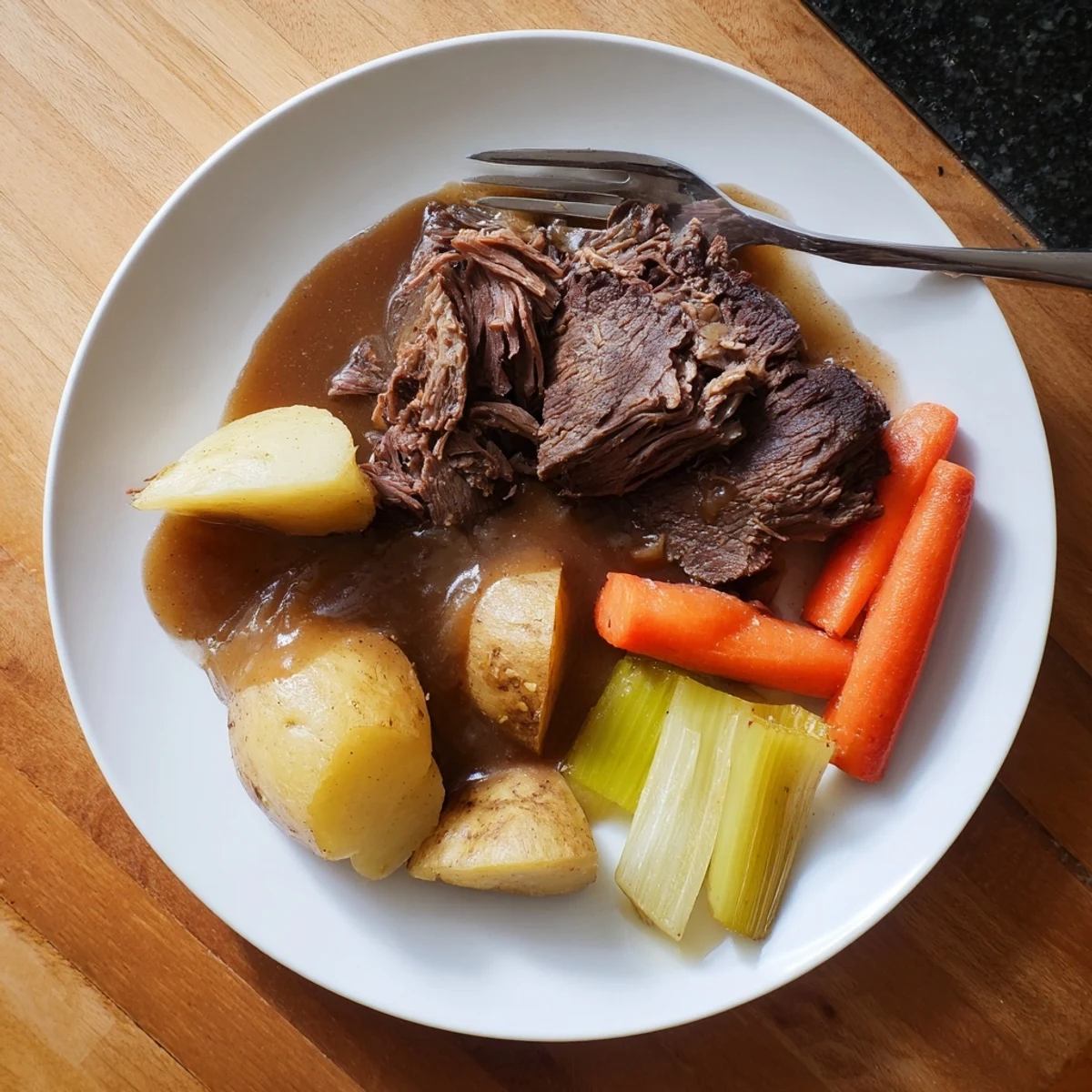 Slow-cooked Southern style pot roast with melt-in-your-mouth beef, chunks of carrots and potatoes, all covered in a thick, flavorful sauce.