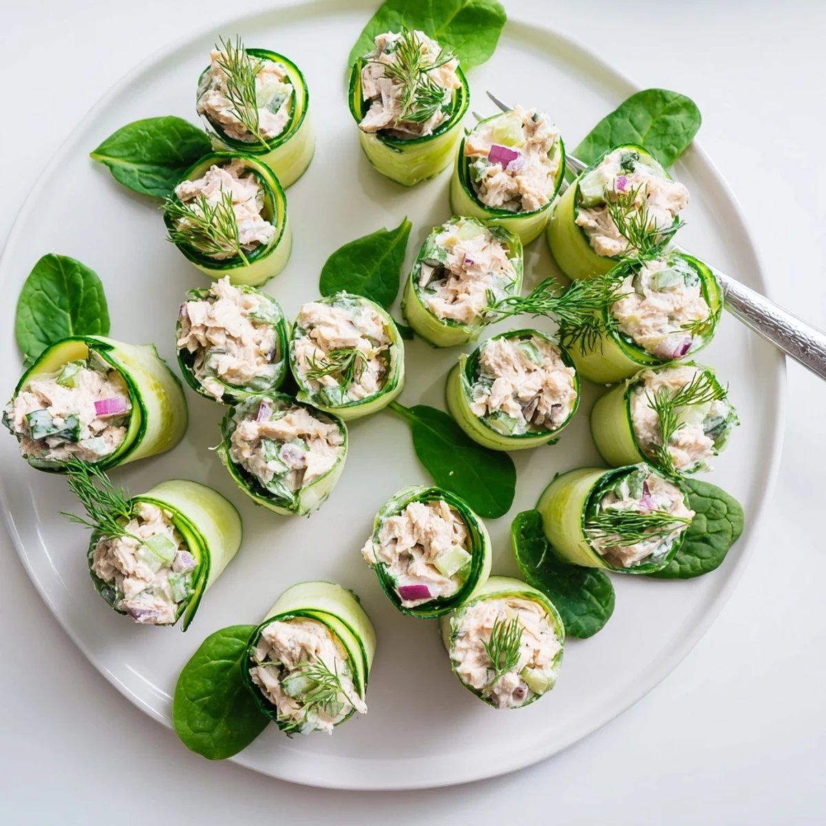 Low carb appetizer featuring spiral cucumber ribbons stuffed with savory chicken salad mixture