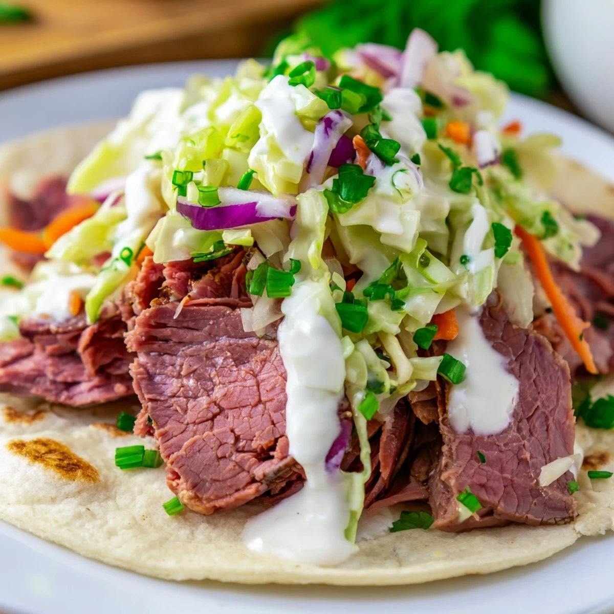 Stuffed Irish tacos piled high with tender corned beef, tangy slaw, and zesty sauce atop a wooden board