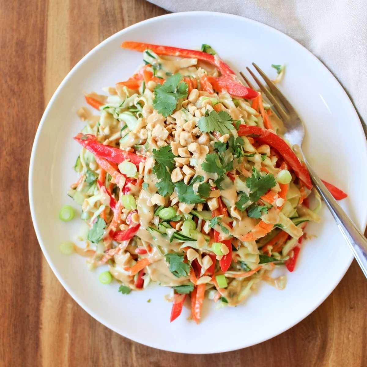 Vibrant gluten-free Thai salad peanut sauce bowl with colorful vegetables and cilantro garnish