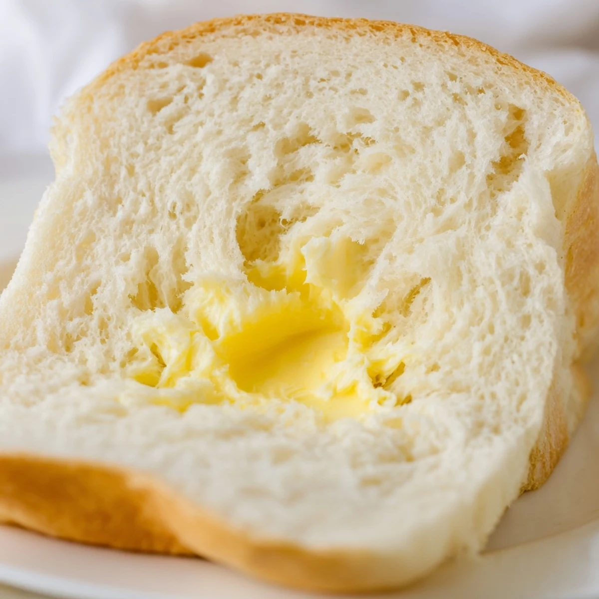 Golden brown homemade Amish white bread loaves with soft interior and brushed butter tops