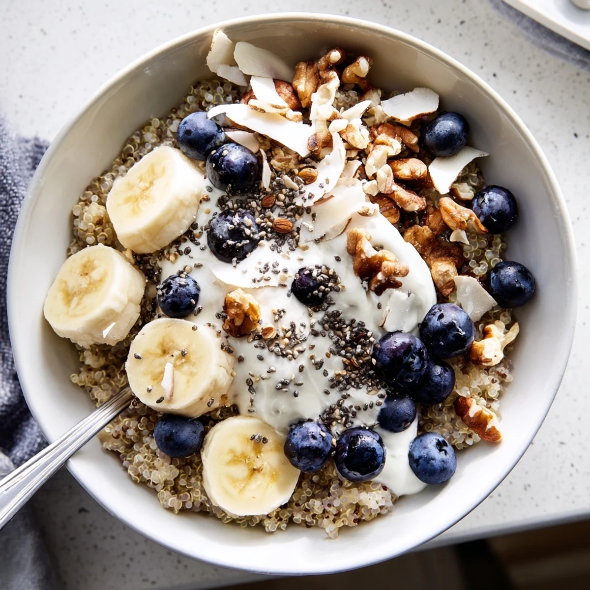 Protein-packed blueberry quinoa breakfast bowl with Greek yogurt fresh fruit and toasted nut toppings for morning energy