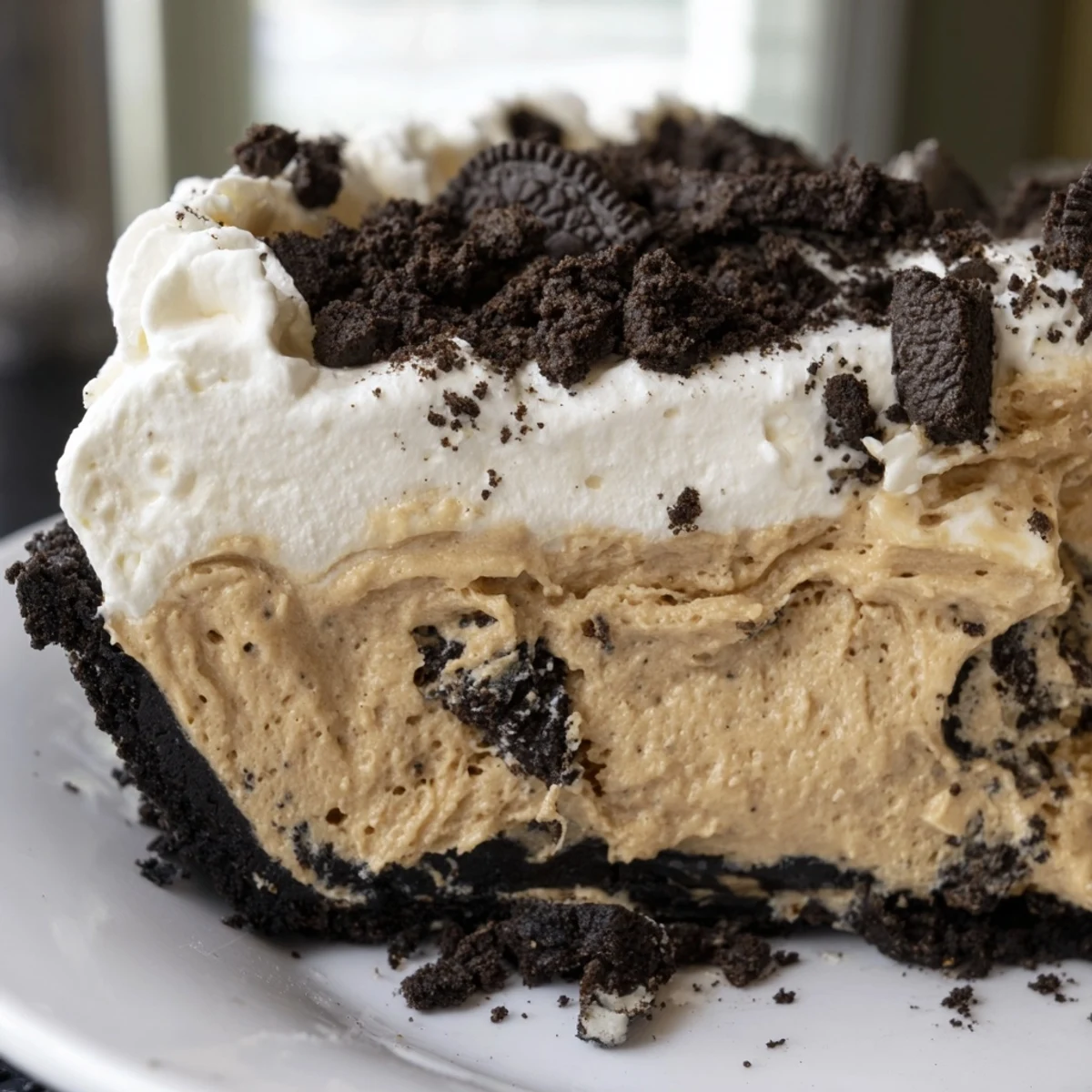 Golden Oreo crust cradling silky Peanut Butter Oreo Pie filling crowned with pillowy whipped cream swirls