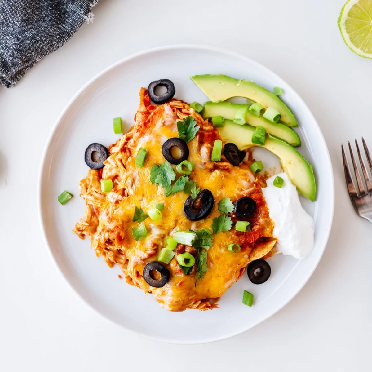 Golden melted cheese tops this cheesy shredded chicken enchilada bake with colorful garnishes