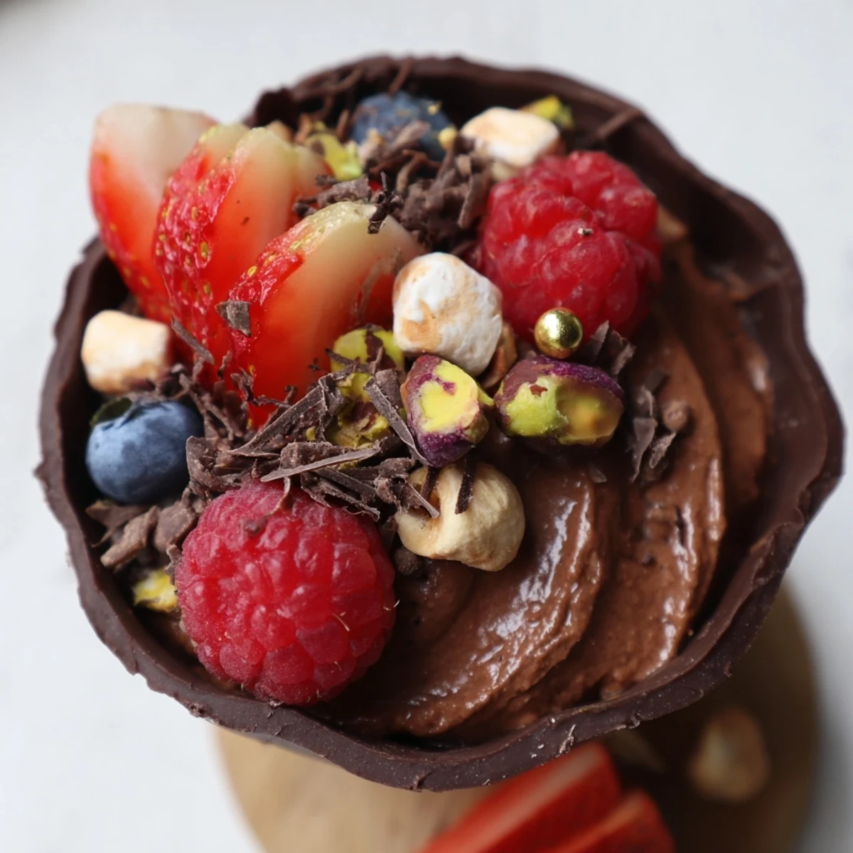 Rich chocolate dessert cups topped with fluffy mousse, fresh strawberries, and chocolate shavings