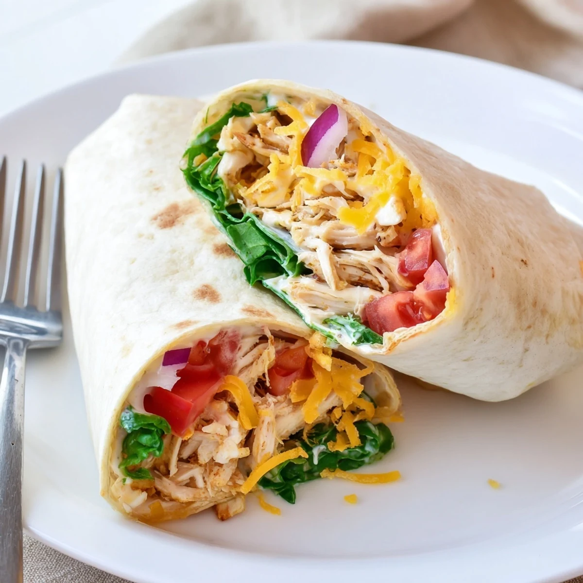 Halved Cheesy Garlic Chicken Wraps, sauce drizzled, steam rising, ready to eat