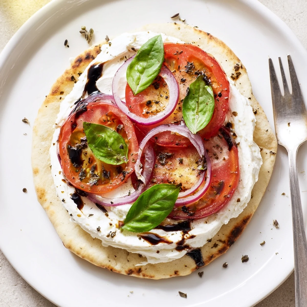 Warm Caprese Pita Pizza With Whipped Garlic Feta, golden edges and bubbling mozzarella