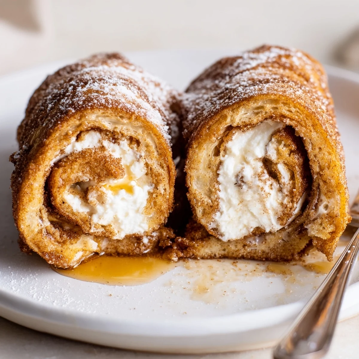 Stacked Cinnamon Roll French Toast Roll Ups dusted with powdered sugar, perfect for brunch