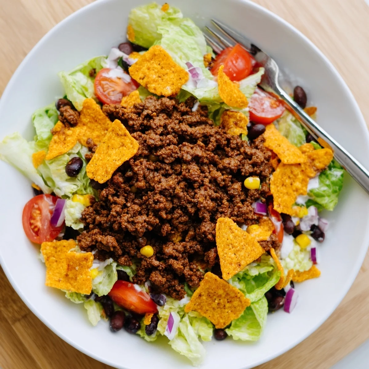A bowl of Simple Doritos Taco Salad with crisp romaine and cheddar