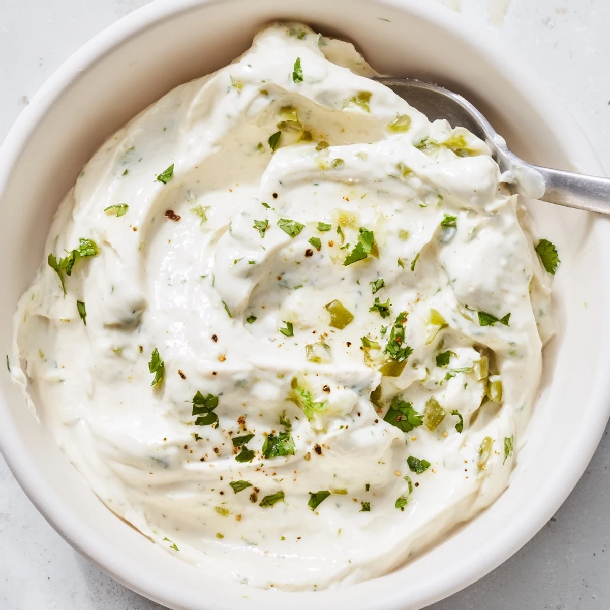 Thick white Mexican sauce dolloped beside grilled chicken with lime wedges